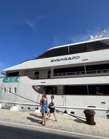 Tourists boarding a modern cruise ship named Avangard.