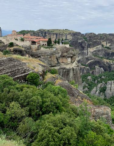 Dramatic cliffside view of a monastery on a mountain.