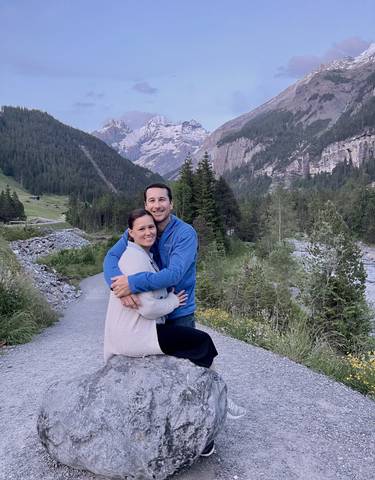 Couple embracing with a mountainous landscape and river.