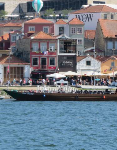 Busy waterfront area with boats and colorful buildings.