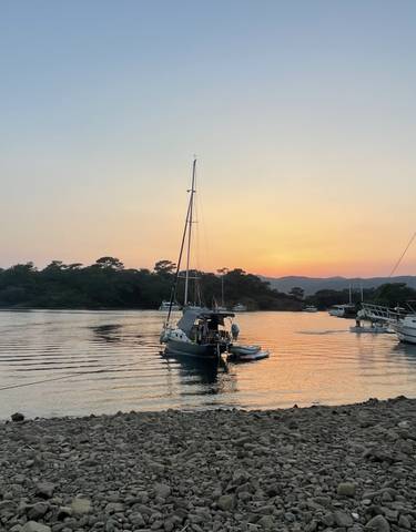 Boats anchored in a serene bay at sunset.