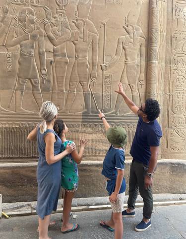 Family looking at ancient Egyptian wall carvings.