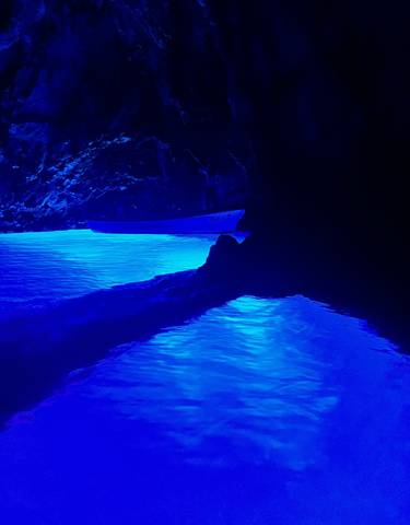 Glow of blue water in a dark cave setting.
