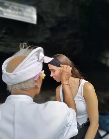 A person performing a traditional ceremony with a flower.