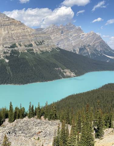 A large turquoise lake surrounded by forested mountains.