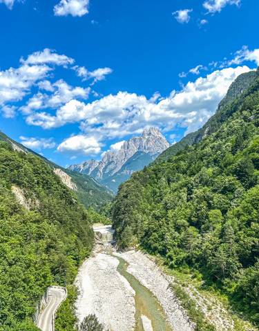 A scenic view of a river canyon flanked by forested mountains.