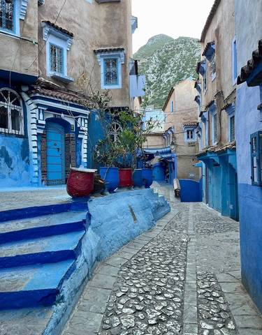 Blue-painted houses lining a narrow cobblestone street.