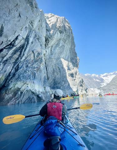 Kayaking near a rocky glacier