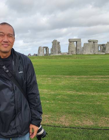 Person with Stonehenge in the background.