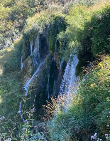 Waterfall cascading down a moss-covered cliff.