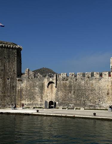 Medieval stone fortress by a waterfront.