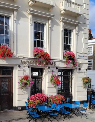Building facade with vibrant flowers in baskets.