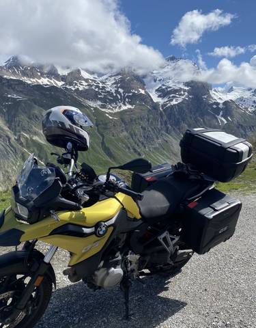 A motorcycle parked with snowy mountain views.