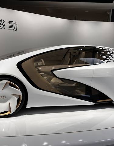 Futuristic concept car on display with Japanese text.