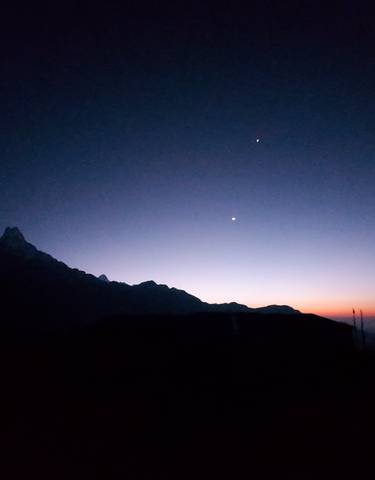Silhouette of mountains with a starry sky at sunset.