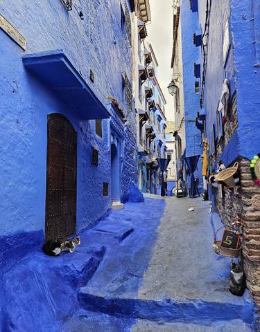 Narrow blue-painted alleyway in a historical city.