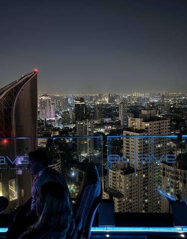 Cityscape view from a rooftop bar at night.