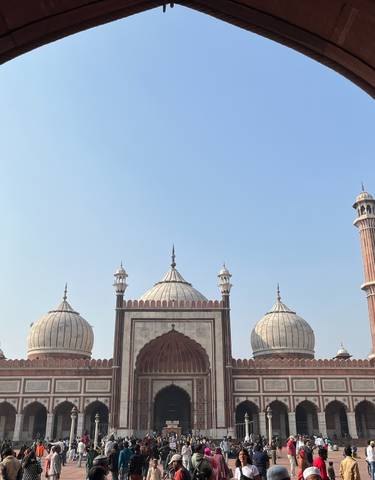 The façade of a mosque viewed through an ornate archway.