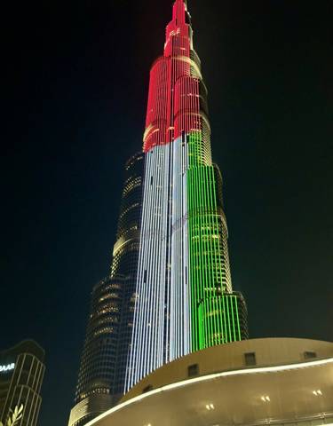 Skyscraper illuminated with colored lights.
