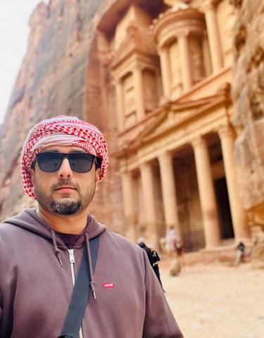 Individual standing in front of the famous rock-cut architecture site.