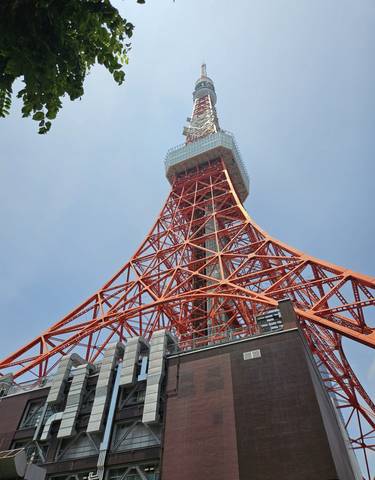 Close-up view of Tokyo Tower against a clear blue sky.
