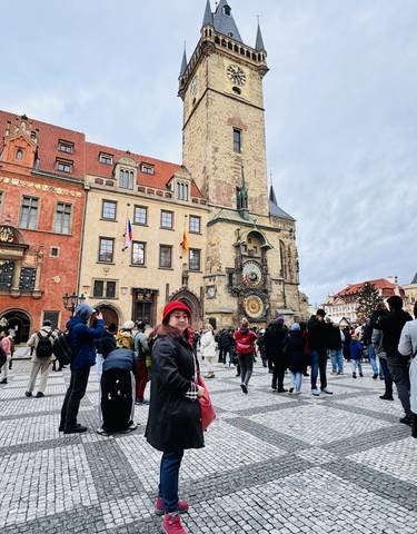 A historical clock tower in a bustling city square.