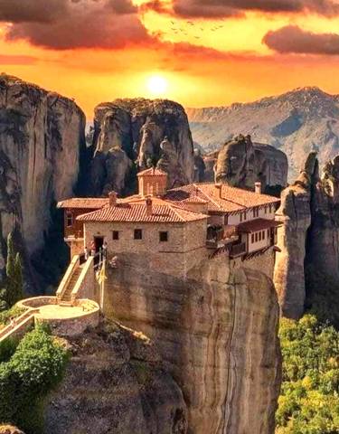 Monastery perched atop a dramatic rock formation.