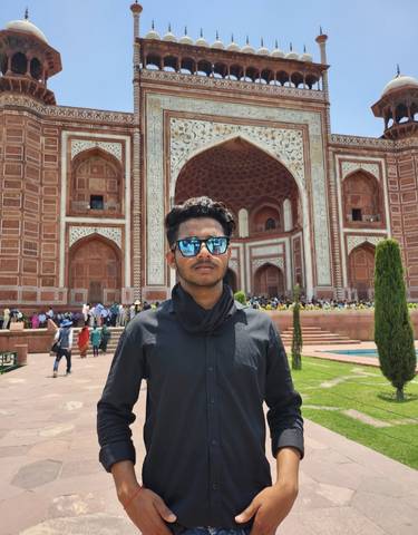 Portrait of a man in sunglasses at a historic site.