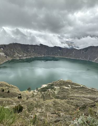 Picturesque view of a crater lake surrounded by hills.