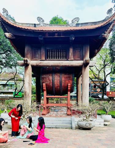Woman posing in front of an ancient temple with a large drum.