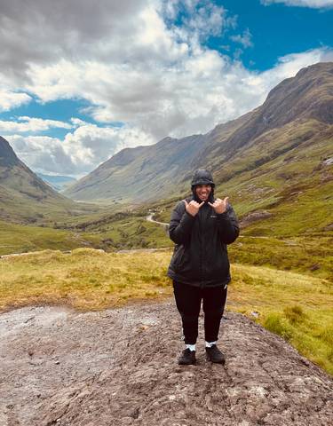 Man posing joyfully in a lush green valley