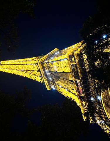 Close-up view of the Eiffel Tower at night.