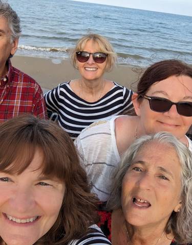 Group of people smiling at the beach.