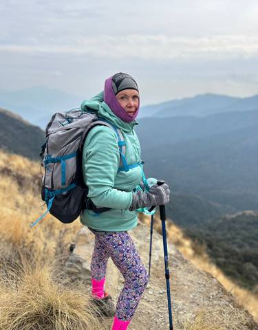 Hiker with backpack posing on a mountain trail.