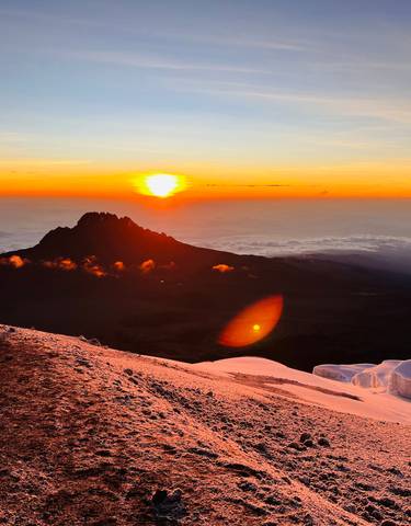 Mountains with snow and a vibrant sunset.