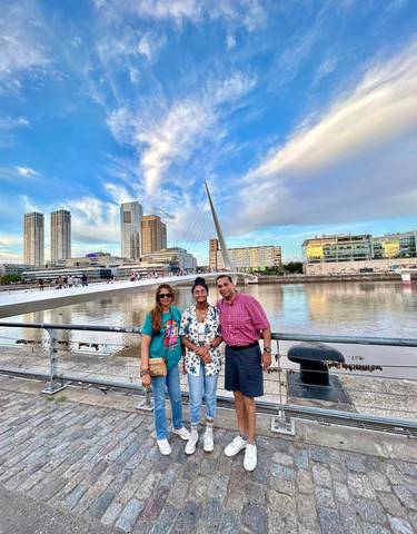 Family posing by a modern urban bridge with skyline.