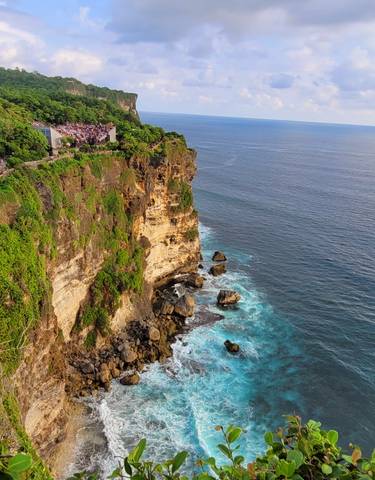 A dramatic cliff with waves crashing against the rocks below.