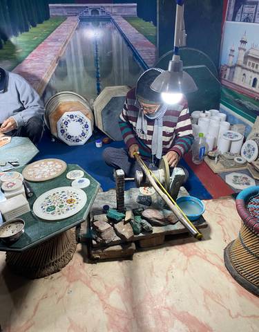 Artisan working on marble inlay at a workshop.