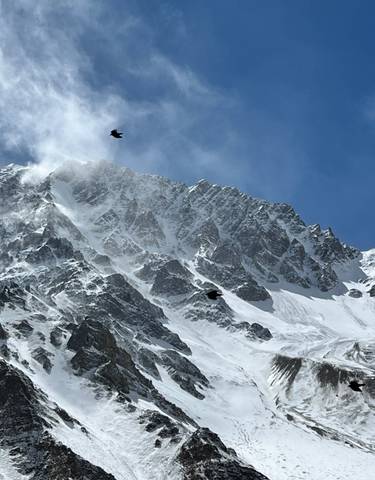 Snow-capped mountain peak against a blue sky.