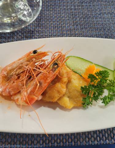 A dish with prawns and vegetables on a plate.