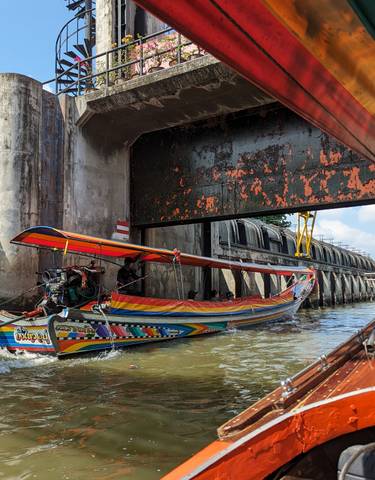 Colorful boat navigating a narrow canal.