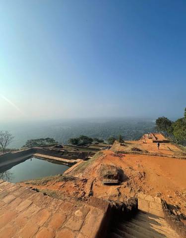 Panoramic view of an ancient site with scattered ruins and hills in the distance.