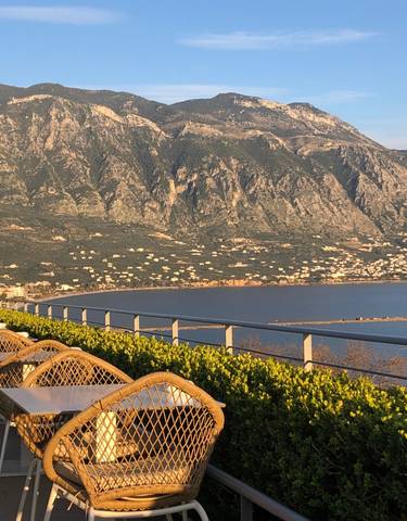 Coastal dining area with stunning mountainous view.