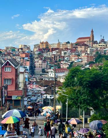 Panoramic view of a bustling hillside town with colorful houses.