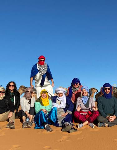 Group with camels sitting in the desert.
