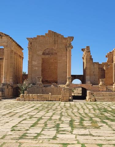 Ancient ruins with columns under a clear blue sky.