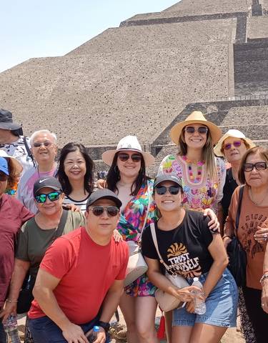 Group posing in front of a pyramid.
