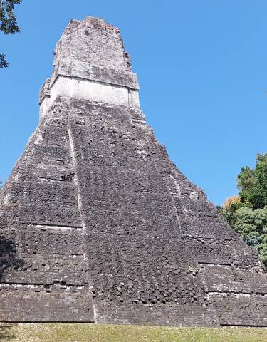 Tall ancient stone temple surrounded by trees.