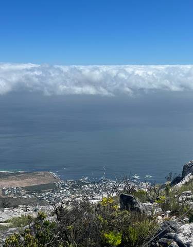 View from a mountain top overlooking clouds and the ocean.