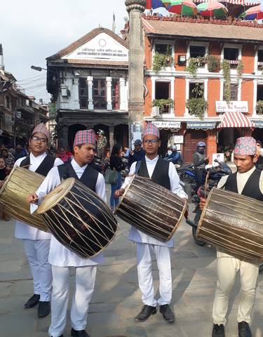 Musicians in traditional attire playing drums during a festival.